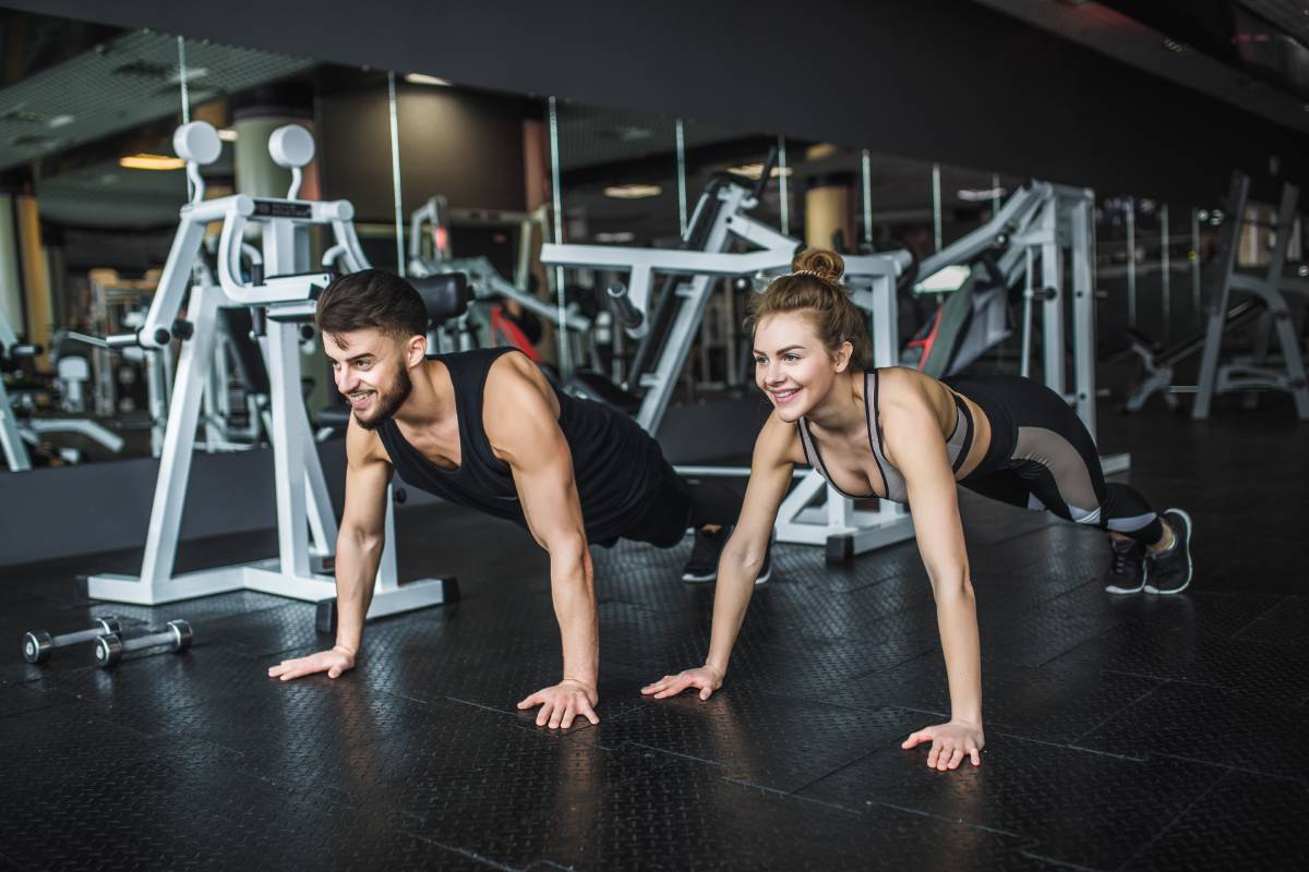 motivated-young-blond-woman-man-middle-workout-standing-plank-with-hands-clenched-together (1)